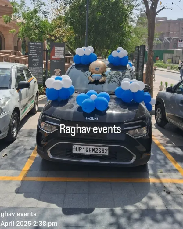 A car decorated with blue and white balloon bunches and a baby boy foil balloon on the hood to welcome the baby home.