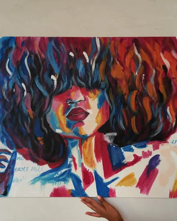 Holding up my large 3x2 ft abstract portrait. The piece uses bold, expressive strokes of color and has handwritten text in the background, adding another layer of meaning.