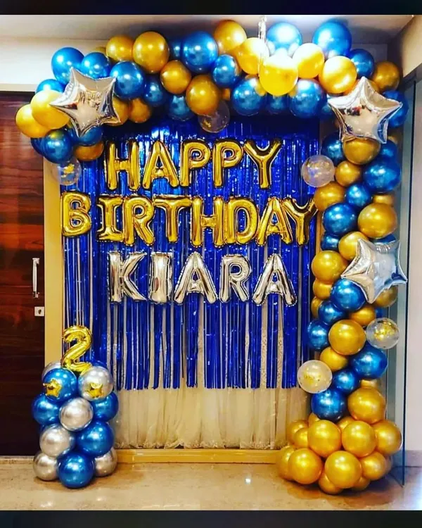 Yeh ek classic birthday decoration hai. Ismein humne blue aur golden metallic balloons ka arch, blue foil curtain backdrop, aur naam ke liye alag se foil letters ka istemal kiya hai.