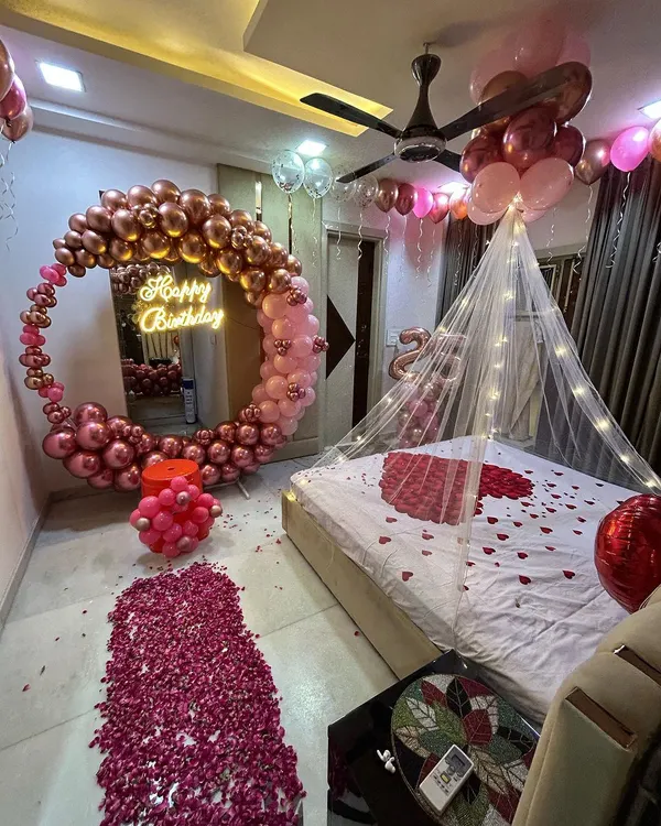 This is the ultimate romantic birthday surprise. I transformed the entire room with a rose gold and pink circular balloon arch, a bed canopy with fairy lights, a path of rose petals, and balloons covering the ceiling. It's a truly immersive and magical experience.