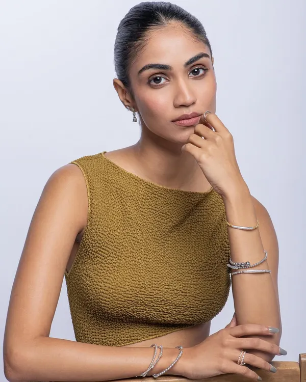 A clean and elegant commercial shot for a jewelry brand. The focus is on the delicate bracelets and the model's sophisticated look.