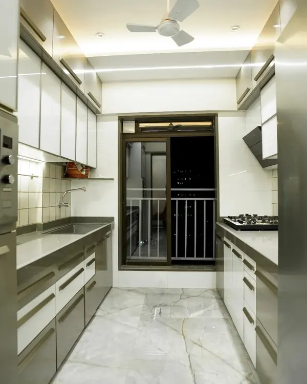 This is a classic parallel kitchen layout, perfect for maximizing storage and efficiency in a compact space. I used a combination of laminate shutters, profile doors with back-painted glass, and sleek aluminum handles.