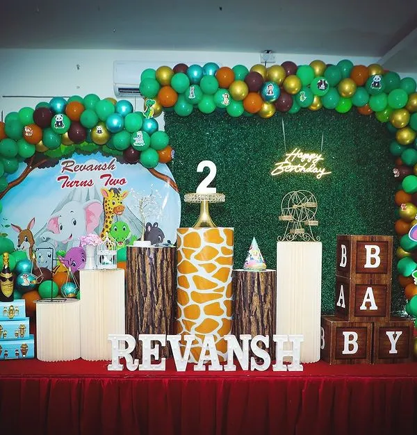 Welcome to the jungle. This 'Wild One' safari theme birthday features a lush green backdrop, animal cutouts, and wood-textured props for a fun adventure.