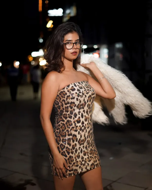 A night shoot on a city street for a fashion brand. The combination of the leopard print dress, faux fur jacket, and eyeglasses creates a bold, edgy look that tells a story.