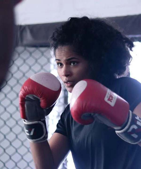 Focus and precision in her eyes. Here, a student practices her boxing combinations, honing the timing that makes a good striker great.