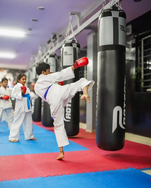 A young student demonstrates power and precision, executing a perfect side kick on a heavy bag. This is where focus and training come together.