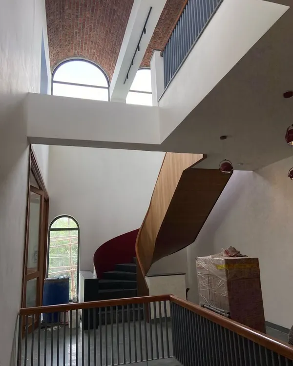 A view of the feature spiral staircase as it transforms from rectilinear to curvilinear, set against the backdrop of a massive 30-foot-long exposed brick vault.