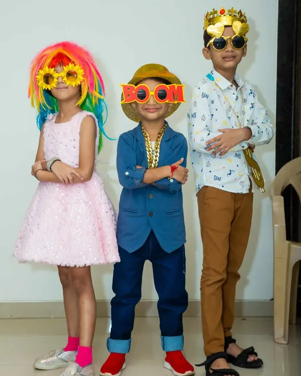 My prop box is always a party highlight. These kids are having a blast posing with a rainbow wig, funky glasses, and a cool gold chain.