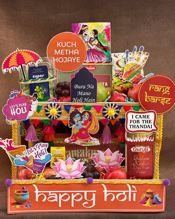 Bringing a *rangeen* blast to your Holi celebrations! This hamper is designed to look like a vibrant street stall, packed with fresh fruits, thandai, gujia, and fun props like water guns and colors to get the party started.
