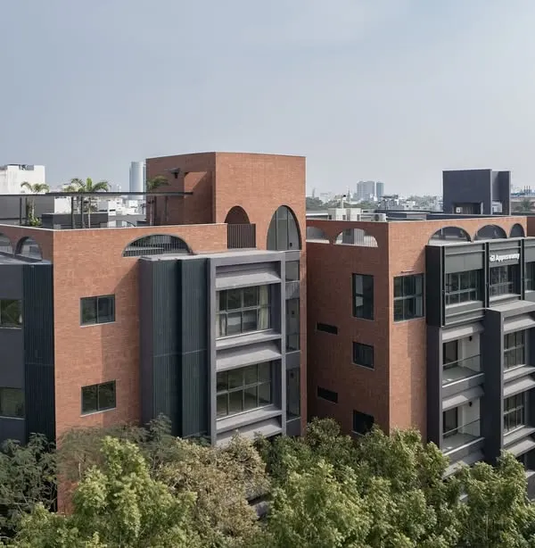 The ARCUS residential building in Chennai, shown here in its urban context. The design uses a combination of brick and dark panels to create a contemporary facade that stands out while respecting the scale of the neighborhood.