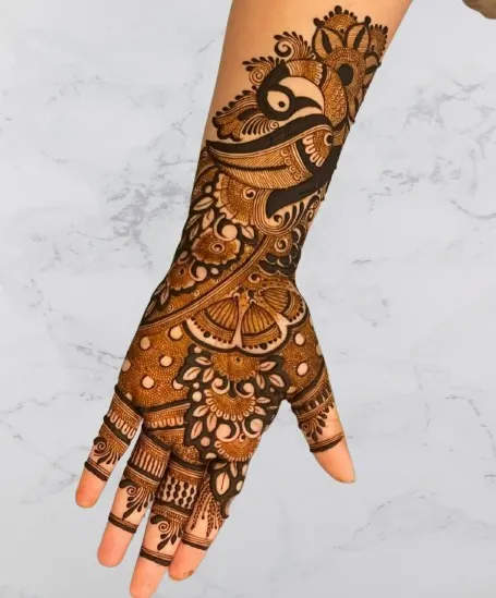 A beautiful design for the back of the hand, featuring a peacock and butterfly, perfect for a sangeet or festive party.