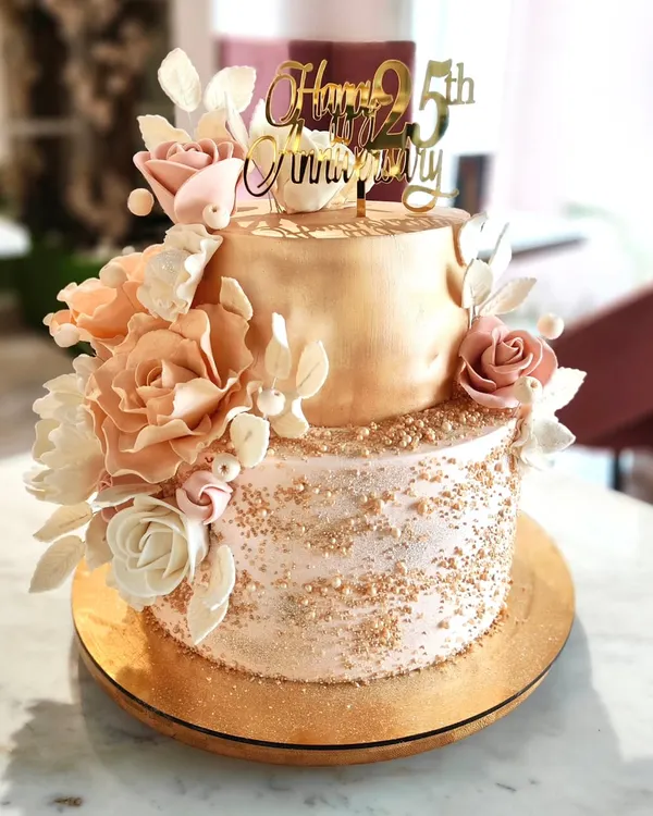 A full view of the 25th-anniversary cake, showcasing the cascade of hand-sculpted sugar flowers against the two-tone metallic and textured buttercream finish.