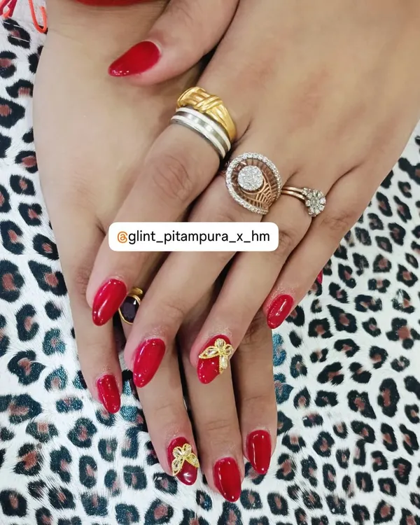 A festive and fun design featuring a vibrant red gel polish on almond-shaped nails. We added intricate, 3D golden bow charms as accent pieces, making this a perfect look for holidays and celebrations.