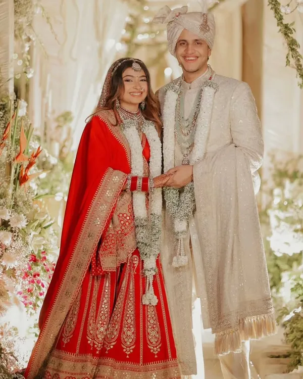 A picture perfect moment for the groom in our custom-tailored ivory sherwani. This ensemble features full-body intricate threadwork, paired with a matching safa and a handcrafted mala, creating a timeless and royal wedding day look.