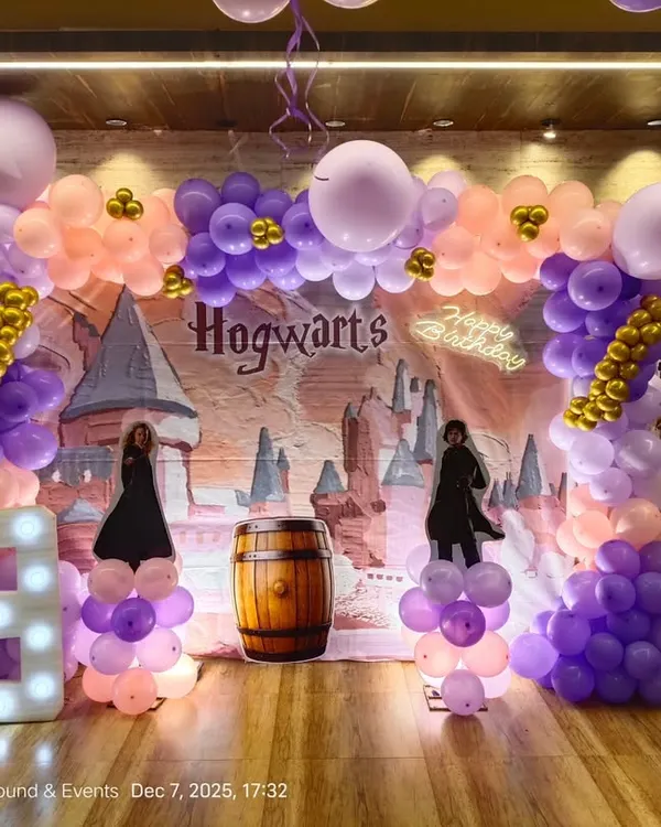 A complete Harry Potter theme for a 9th birthday. The stage features a Hogwarts backdrop, character cutouts of Harry, Hagrid, and Dumbledore, a light-up number '9', and a balloon arch in house colors.