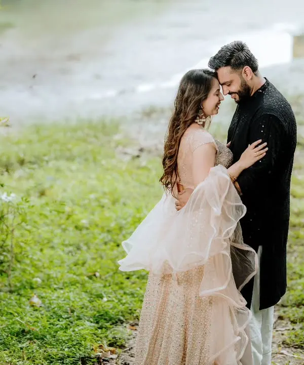 A tender moment between a couple in a lush green, natural setting. This intimate portrait focuses on their quiet connection, with the soft, diffused light adding to the romantic mood.
