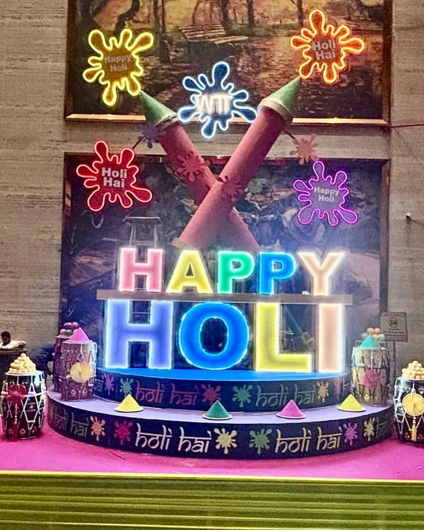 We created this vibrant, large-scale installation for a Holi celebration, featuring custom-lit 'Happy Holi' lettering and oversized pichkari props. This type of illuminated centerpiece becomes the focal point for any festive gathering.