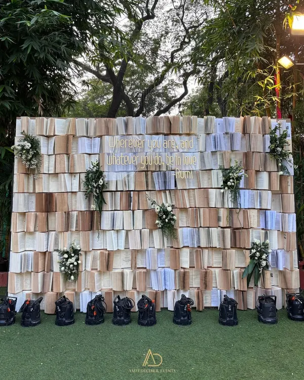 A unique and literary photo backdrop created from hundreds of open books, with a beautiful Rumi quote in gold. This is perfect for couples who are book lovers.