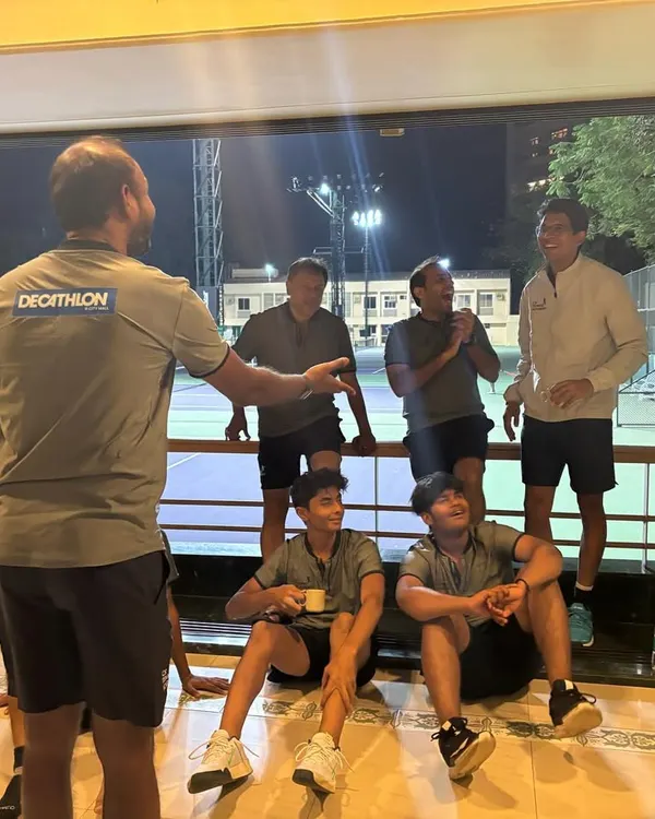 The best conversations happen off the court. Here, our coach engages with the team in a relaxed setting, fostering a comfortable environment where everyone can connect on a personal level.
