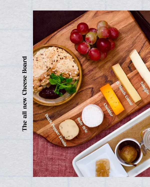 Our all new cheese board, featuring a curated selection of artisanal cheeses like Dutch Pepper Gouda and Baby Brie. Paired with house-made accompaniments, it's the perfect companion to a glass of wine.