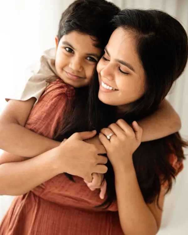 A warm, loving hug from behind. This portrait of a mother and her son is filled with a sense of comfort, safety, and unconditional love.