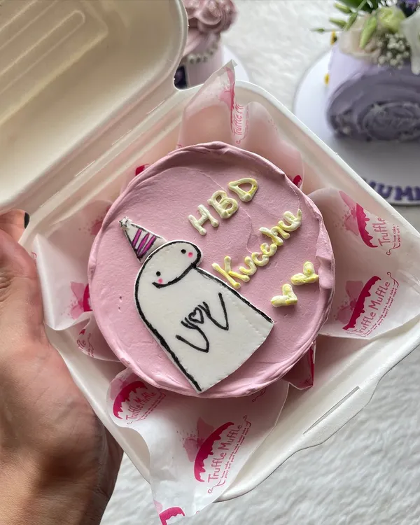 This cute character bento cake is a popular choice for birthdays. The simple hand-drawn design on a pink frosted mini cake makes for a sweet and personal gift.