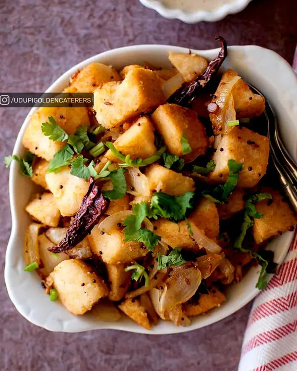 Our Masala Idli Fry is a delicious and savory breakfast option. We take soft, steamed idlis, cut them into cubes, and sauté them with onions, mustard seeds, and aromatic spices for a flavorful twist.
