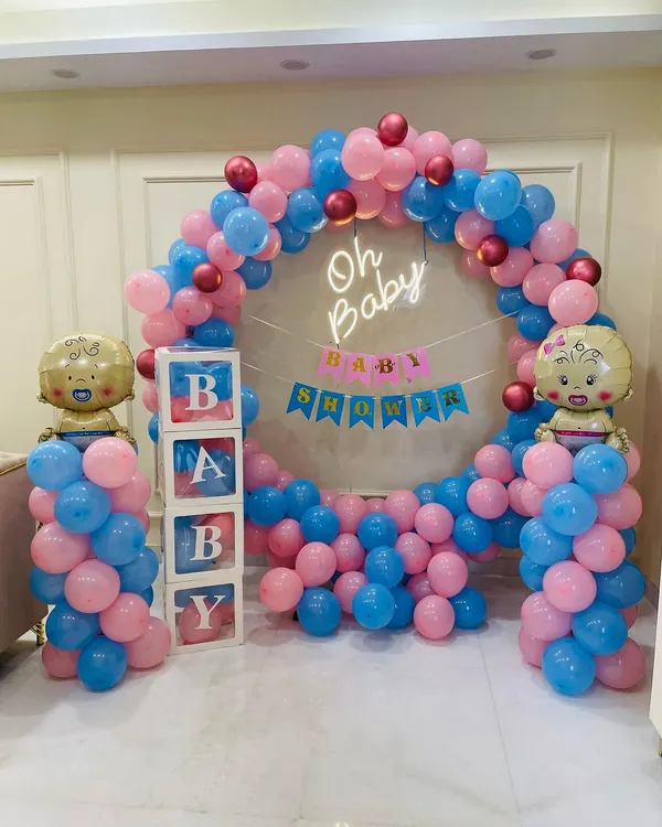 This is a popular gender-neutral baby shower design featuring a full circle balloon arch with both pink and blue balloons. The setup is completed with an "Oh Baby" neon sign, a "Baby Shower" banner, and transparent "BABY" boxes.