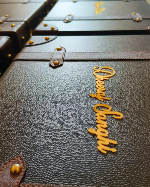 A row of dapper leatherette trunks, each personalized with a name in gold acrylic. These were created to celebrate a 20-year partnership between Axis Bank and Yes Bank, serving as a sophisticated employee recognition gift.