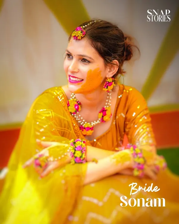 A beautiful bride smiling during her Haldi ceremony, with turmeric paste on her cheek. We capture the joy and tradition of this vibrant pre-wedding event.
