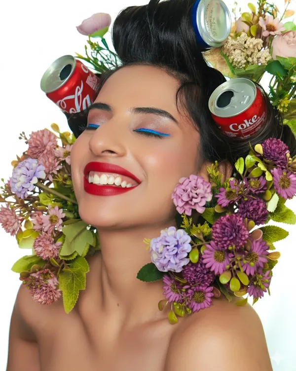 A moment of pure joy in our creative Coke can shoot. This shot captures a beautiful smile, framed by the quirky hair rollers and colorful flowers.