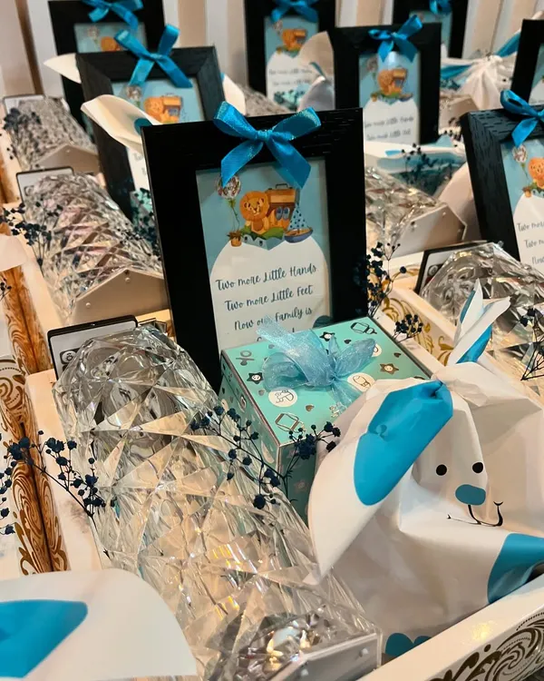A closer look at the details of my "It's a Boy" baby announcement hampers. Each gift includes a small framed picture, a diamond-cut lamp, and other beautifully wrapped goodies.