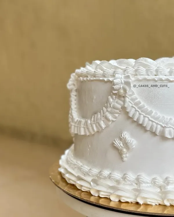 A close-up of the intricate piping on one of our white vintage cakes. The delicate ruffles and swags are piped by hand to create a classic, elegant look.
