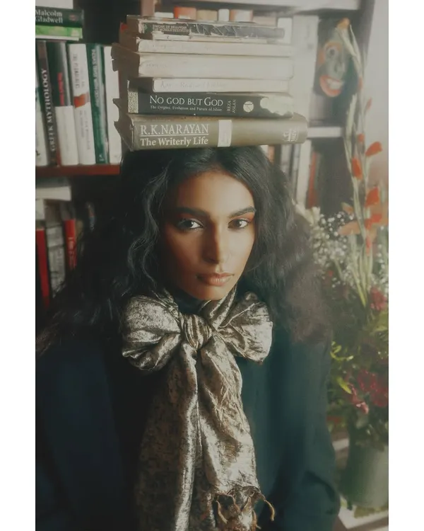 A key image from my 'Roots' editorial. The styling choice of balancing books on the model's head is a direct metaphor for carrying one's history and culture. The oversized bow adds a touch of soft, stylistic contrast.