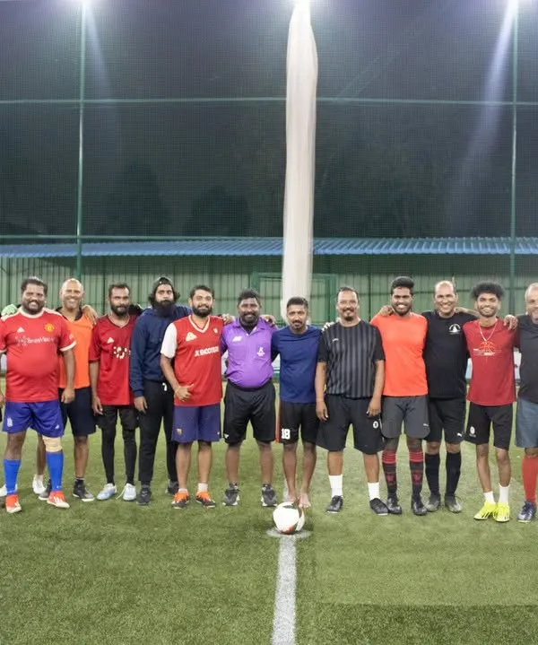 A group photo of adult players from different corporate teams before their match begins on our turf.