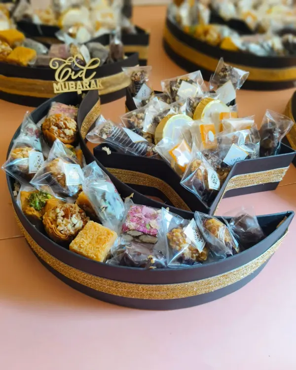 My 'Chand Taara' Eid gourmet hampers were a big hit this season. This crescent-shaped platter is overflowing with delicious treats like baklava, date and almond bites, and other sweets.