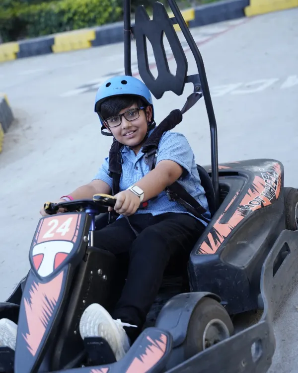 A happy racer is buckled in and ready to hit the track. Our karts are designed for kids, ensuring a safe and exciting go-karting experience.