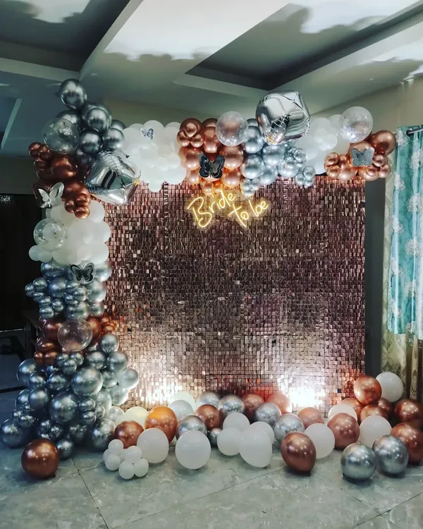 I create stunning photo backdrops like this rose gold shimmer wall for a bridal shower. The setup includes a custom neon sign and an elaborate balloon arch with chrome, white, and metallic balloons to make your event truly memorable.