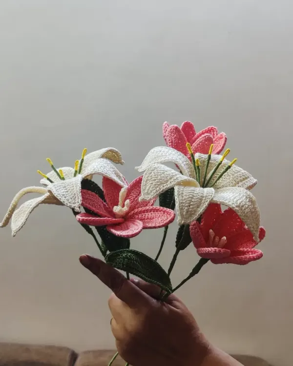A hand-held bouquet showcasing our intricately crocheted lilies and tulips. The combination of white lilies with pink and coral tulips creates a soft, romantic arrangement that lasts forever.