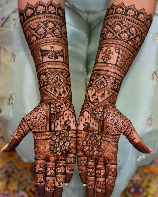 This full bridal mehendi is a masterpiece of symmetry and detail. It features majestic peacocks, auspicious symbols, and geometric patterns, creating a rich and traditional look for the bride.