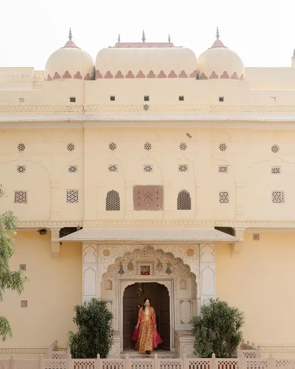 A bride stands in the doorway of a Jaipur palace. I use the grandeur of destination venues to create portraits that feel both personal and epic in scale.