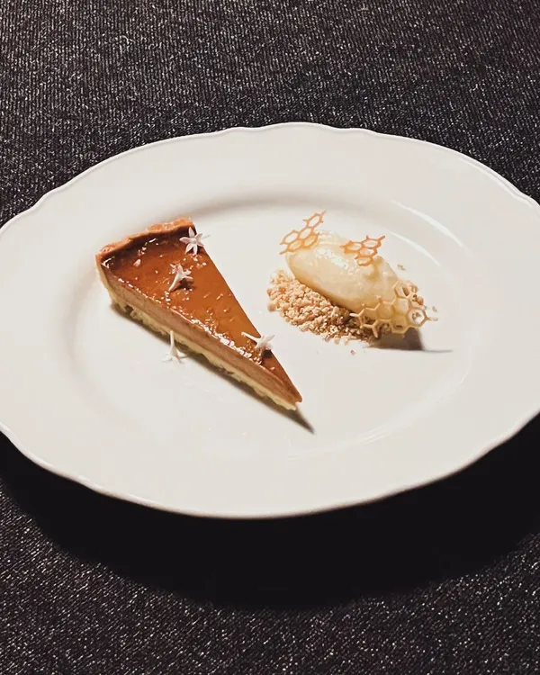 A slice of my caramelized Muscovado custard tart, served with house-made cinnamon ice cream. It's rich, creamy, and deeply satisfying.