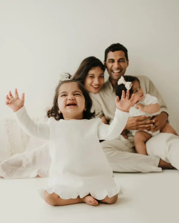 A moment of pure, chaotic joy with twin girls and their parents. This lifestyle family session captures the fun and energy of life with toddlers.