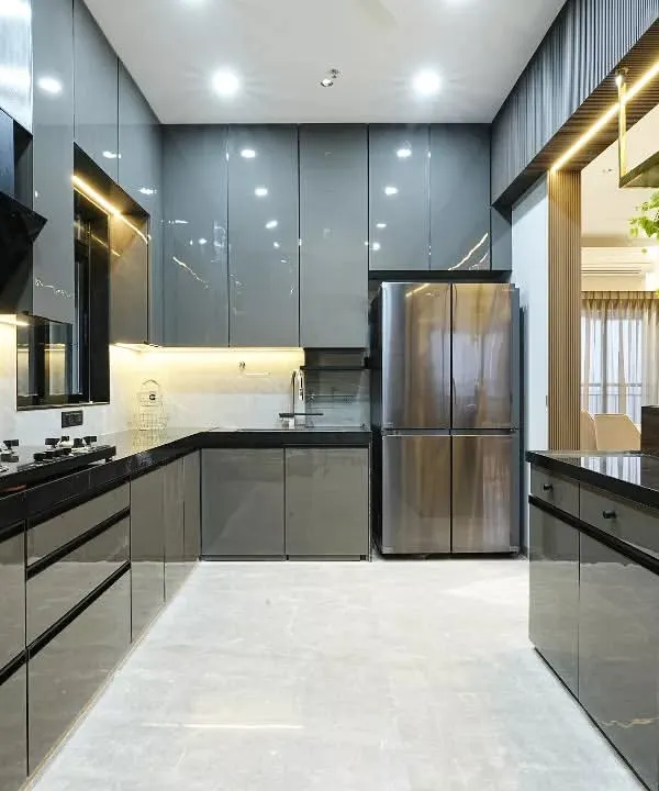 This open kitchen concept with a high-rise island counter embodies sleek modernism and understated opulence. The charcoal grey tone seamlessly blends with the kitchen's glossy black cabinetry, creating a cohesive, monochromatic palette that invites both culinary creativity and social interaction.