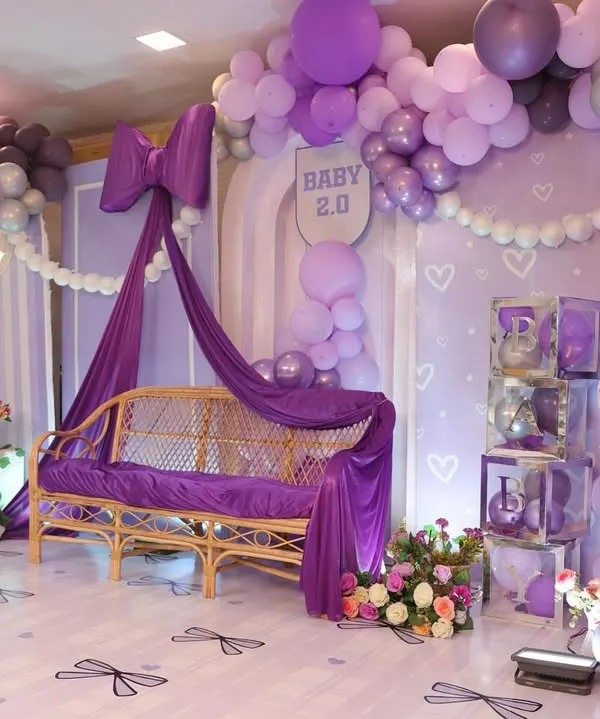 A dreamy baby shower with a purple bow theme. I used cascading drapes, a beautiful rattan sofa, and a giant teddy bear to create a soft and elegant space for the mom-to-be.