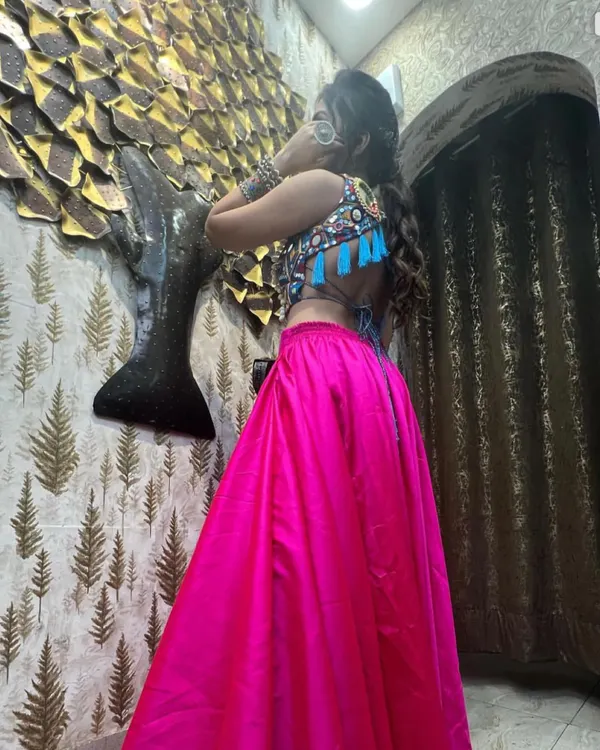 The back of my Navratri outfit, featuring a stunning mirror-work blouse and a bright pink skirt. The backless design with tassels adds a playful and modern touch to this traditional garba look.
