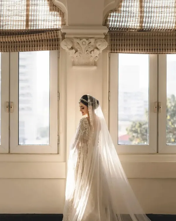 A bride bathed in soft window light. We find these perfect spots for timeless and artistic portraits that capture the bride's elegance.