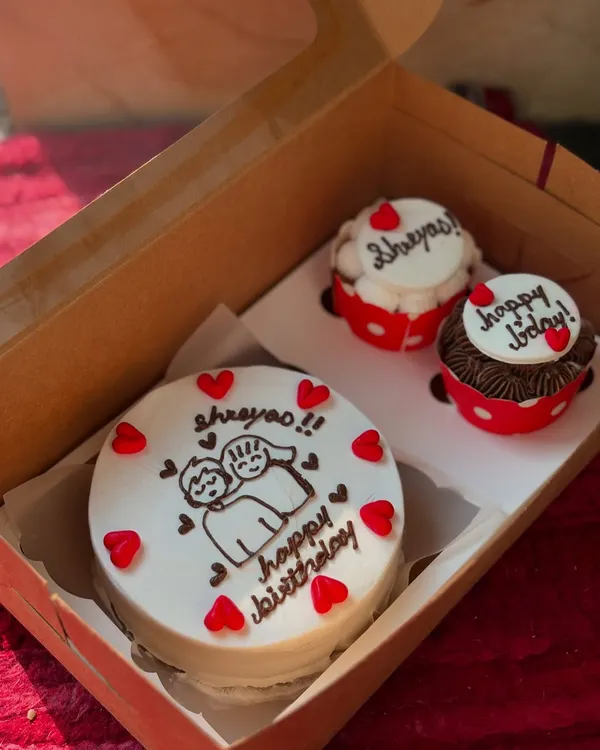 A sweet birthday gift combo, featuring a custom illustrated bento cake and two matching cupcakes.