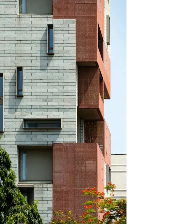 The facade of J-House is a composition of stone and brick, with deep, shaded verandahs. The design is a response to the urban environment, creating a private oasis that engages with the elements thoughtfully.