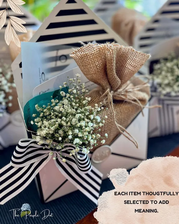 These envelope-styled boxes are perfect for favors or small surprises. Each item inside is thoughtfully selected, and the exterior is adorned with a striped ribbon, baby's breath, and a wax seal for a touch of old-world charm.